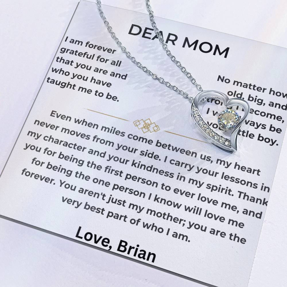 Close-up of silver heart pendant resting on a Dear Mom message card