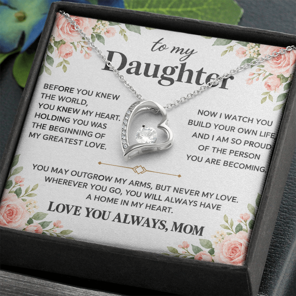 Heart pendant necklace displayed in a black presentation box on a dark surface.