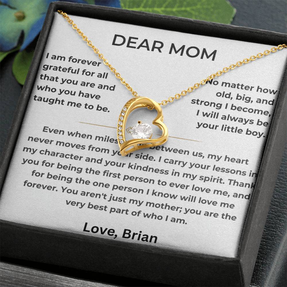 Gold heart pendant and message card presented in a black jewellery box