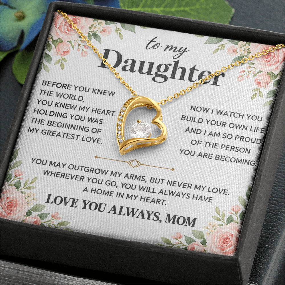 Close-up gold-tone heart pendant necklace displayed on the floral Daughter message card.