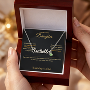 Hands holding an open mahogany-style box with an Isabella name necklace and Daughter message card from Dad.